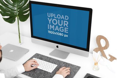 Mockup of a Man Using an iMac in a Minimalist Setting 2139-el