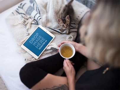 Mockup of a Woman in Bed Watching Her iPad Mini and Holding a Coffee Cup